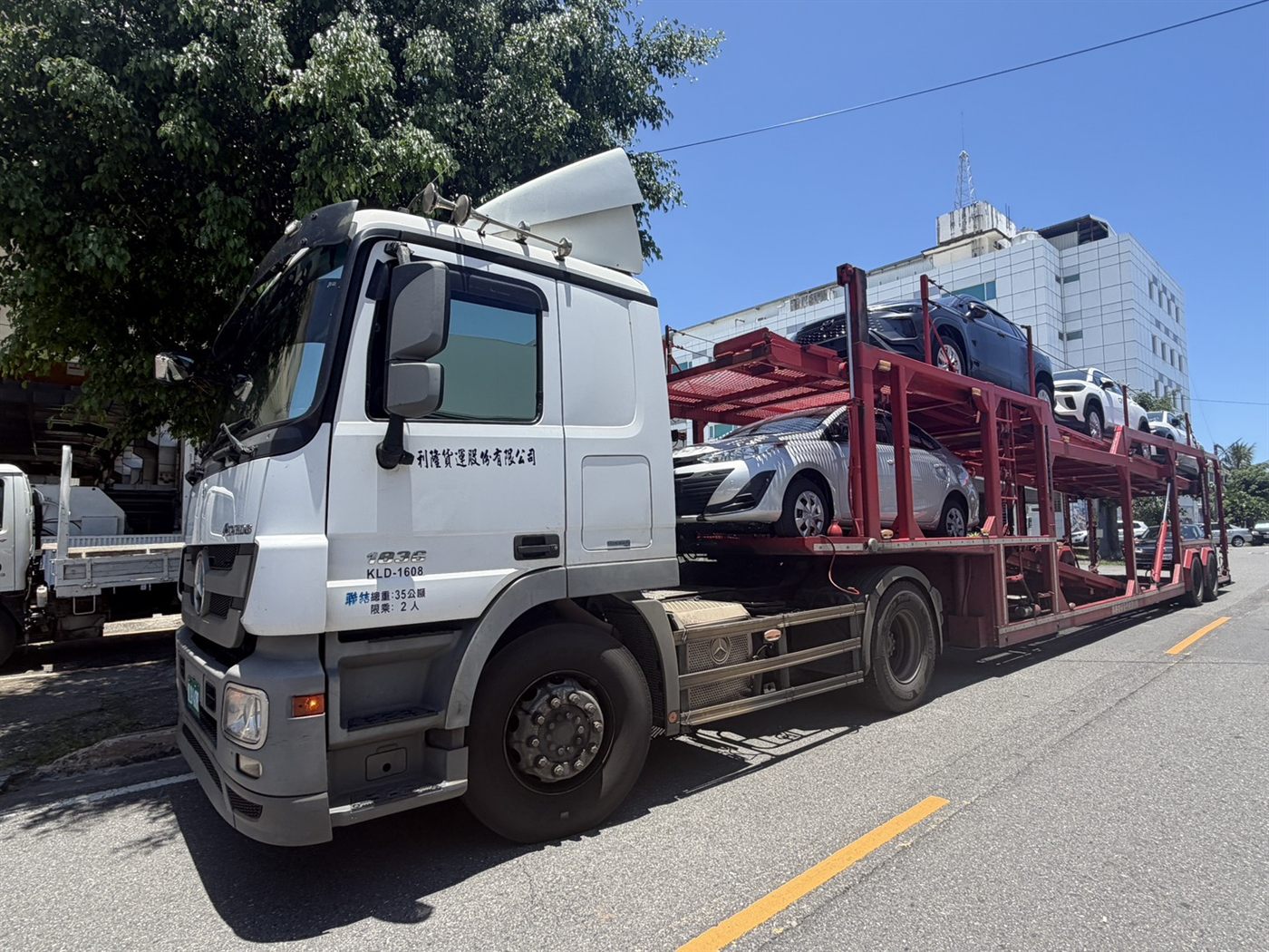 利隆板車載運多輛新車於市區道路行進
